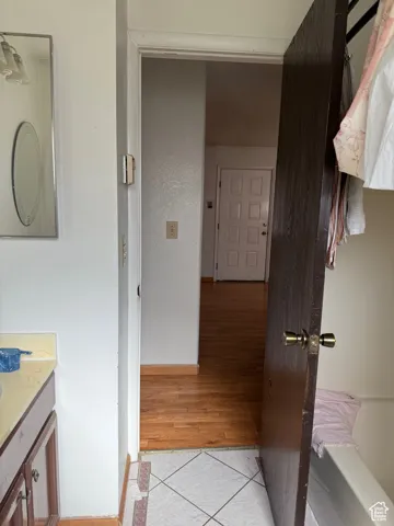 Corridor featuring light tile patterned flooring and baseboards