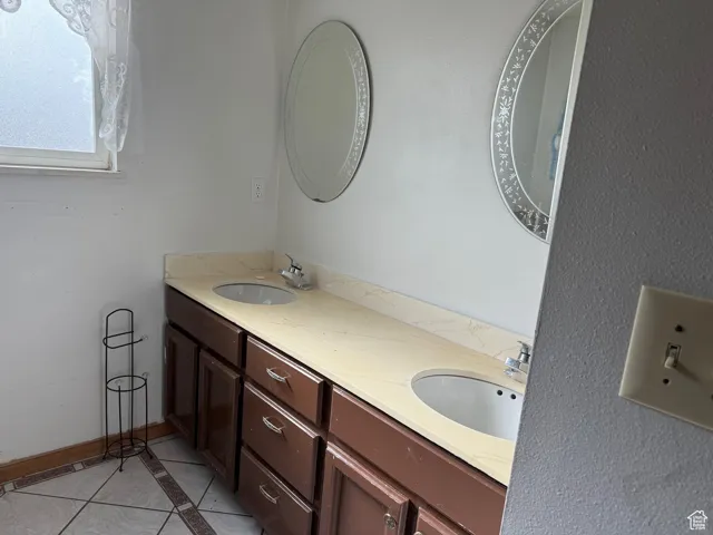 Full bath featuring tile patterned flooring, a sink, and double vanity