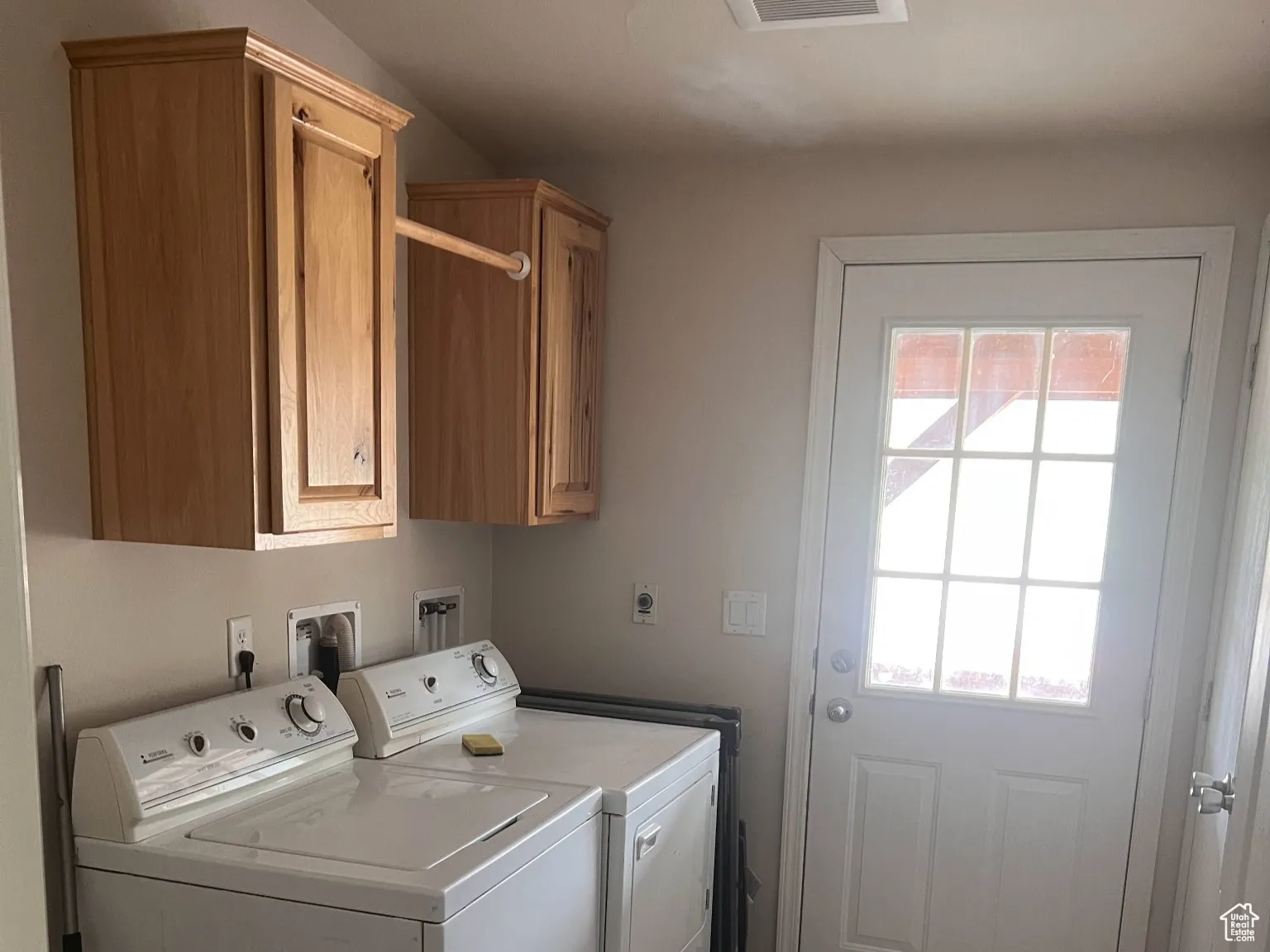 Laundry area featuring visible vents, cabinet space, and washer and clothes dryer