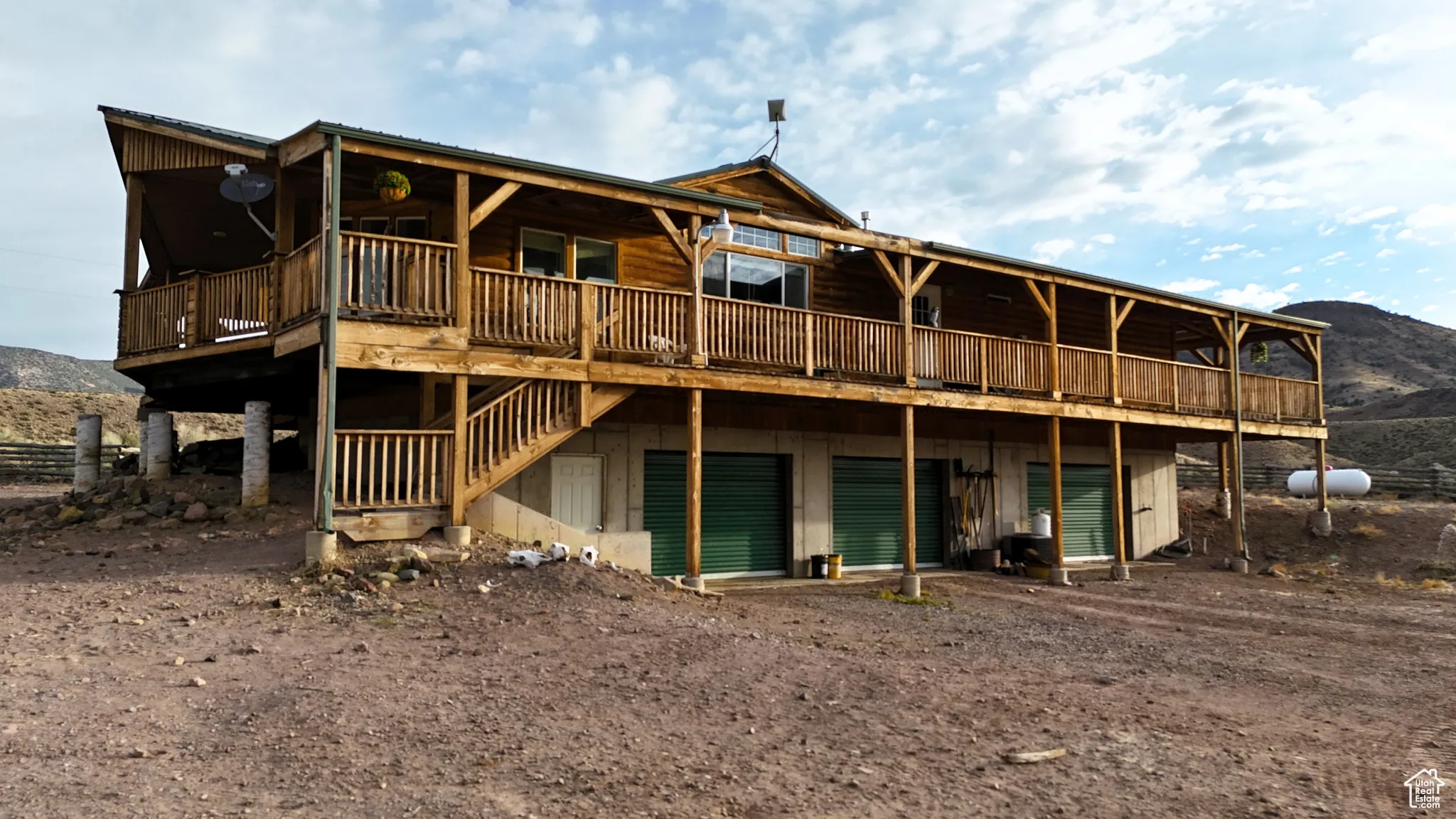 Rear view of house with driveway, a deck with mountain view, and a garage