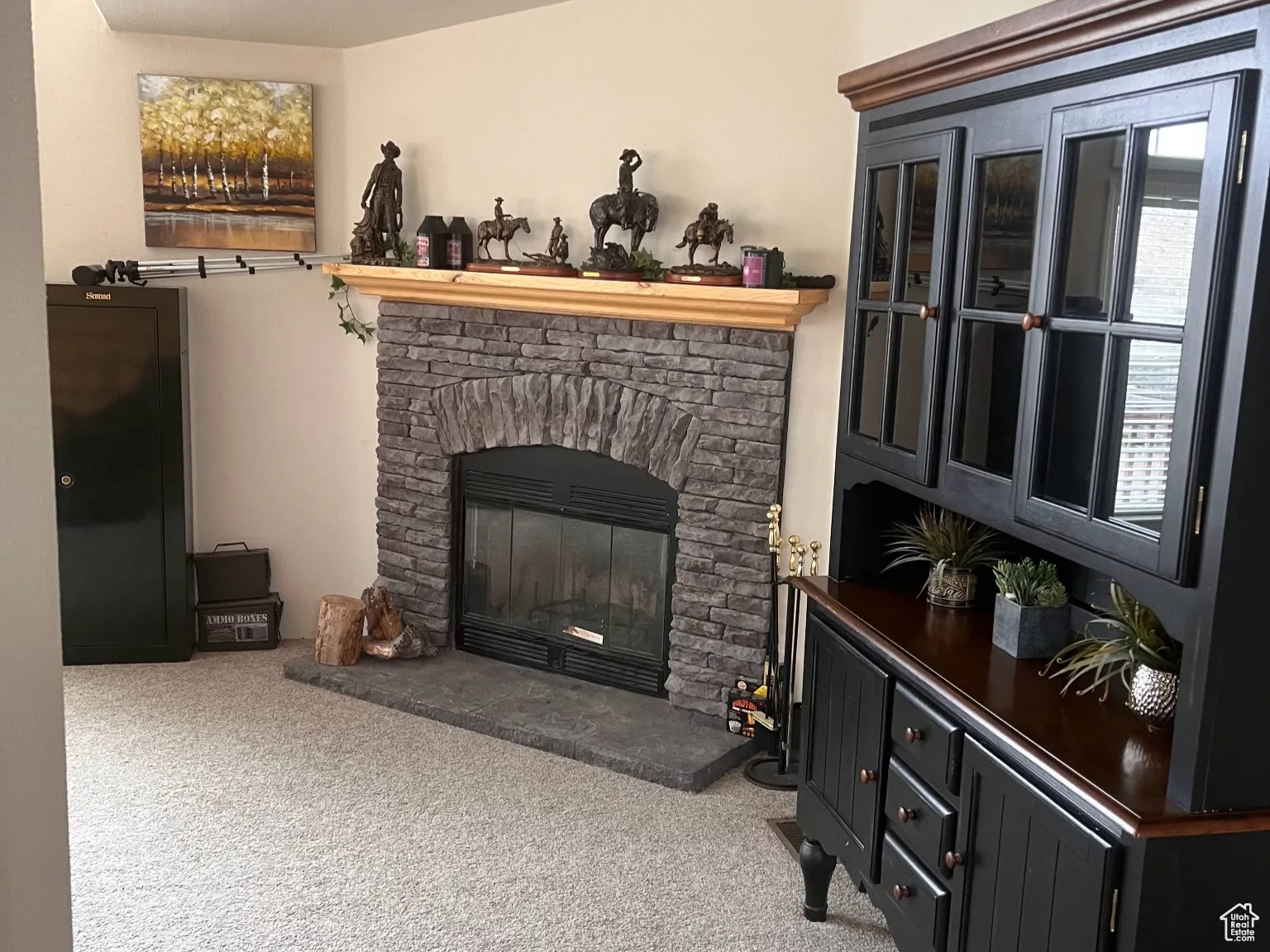 Living room featuring carpet flooring and a stone fireplace