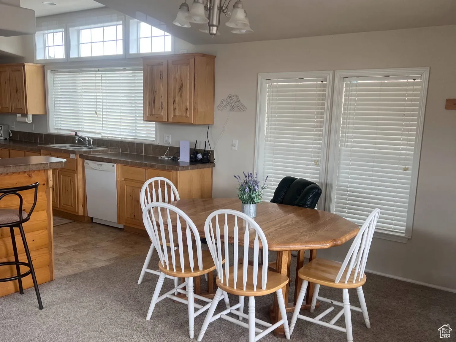 Dining area with light colored carpet and a chandelier