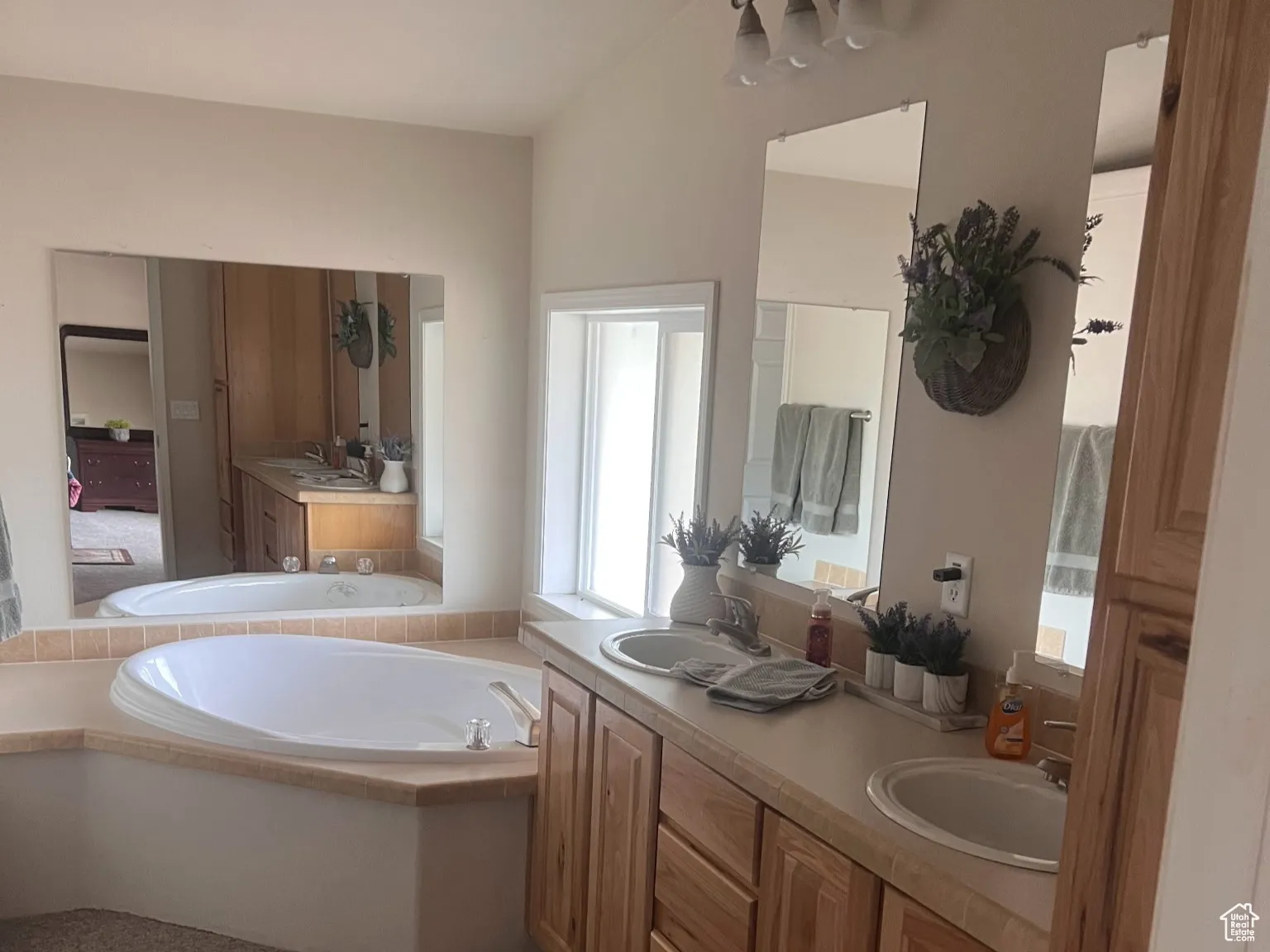 Bathroom featuring double vanity, a garden tub, carpet floors, and a sink