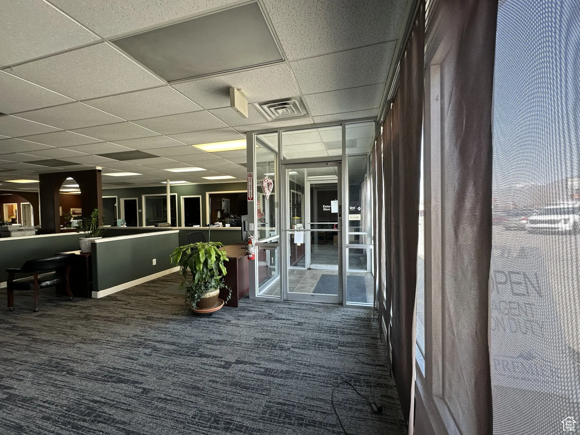 Hall featuring visible vents, carpet floors, and a drop ceiling