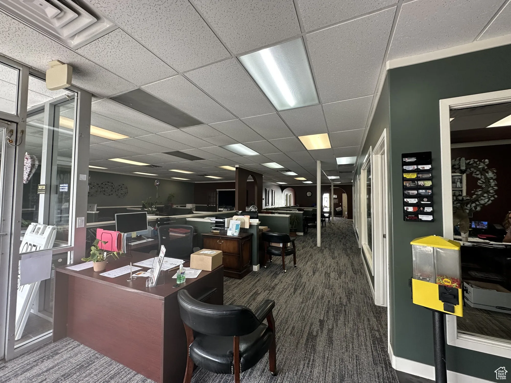 Office with visible vents, dark colored carpet, and a drop ceiling