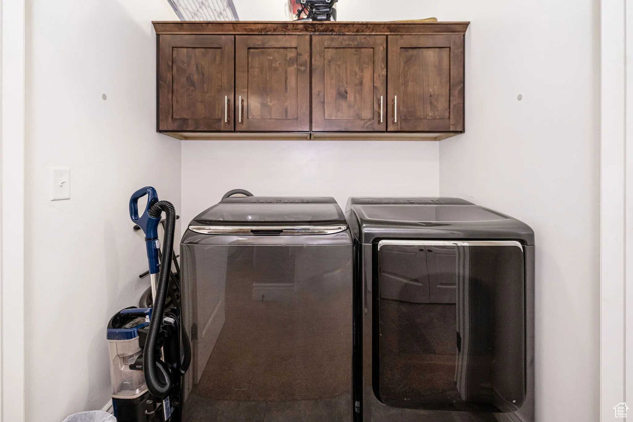 Washroom with washer and clothes dryer and cabinet space