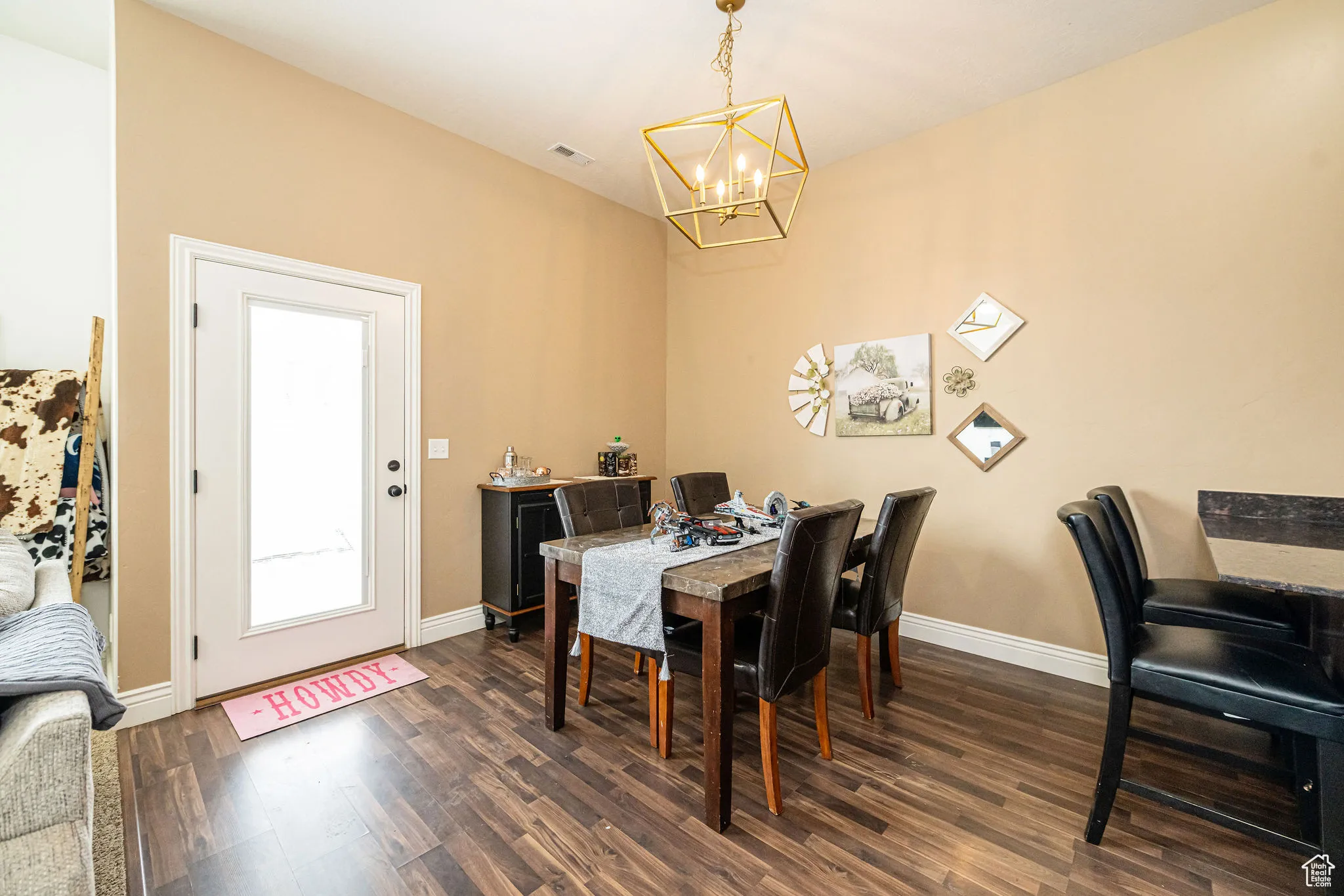 Dining area with visible vents, baseboards, dark wood-style floors, and a chandelier