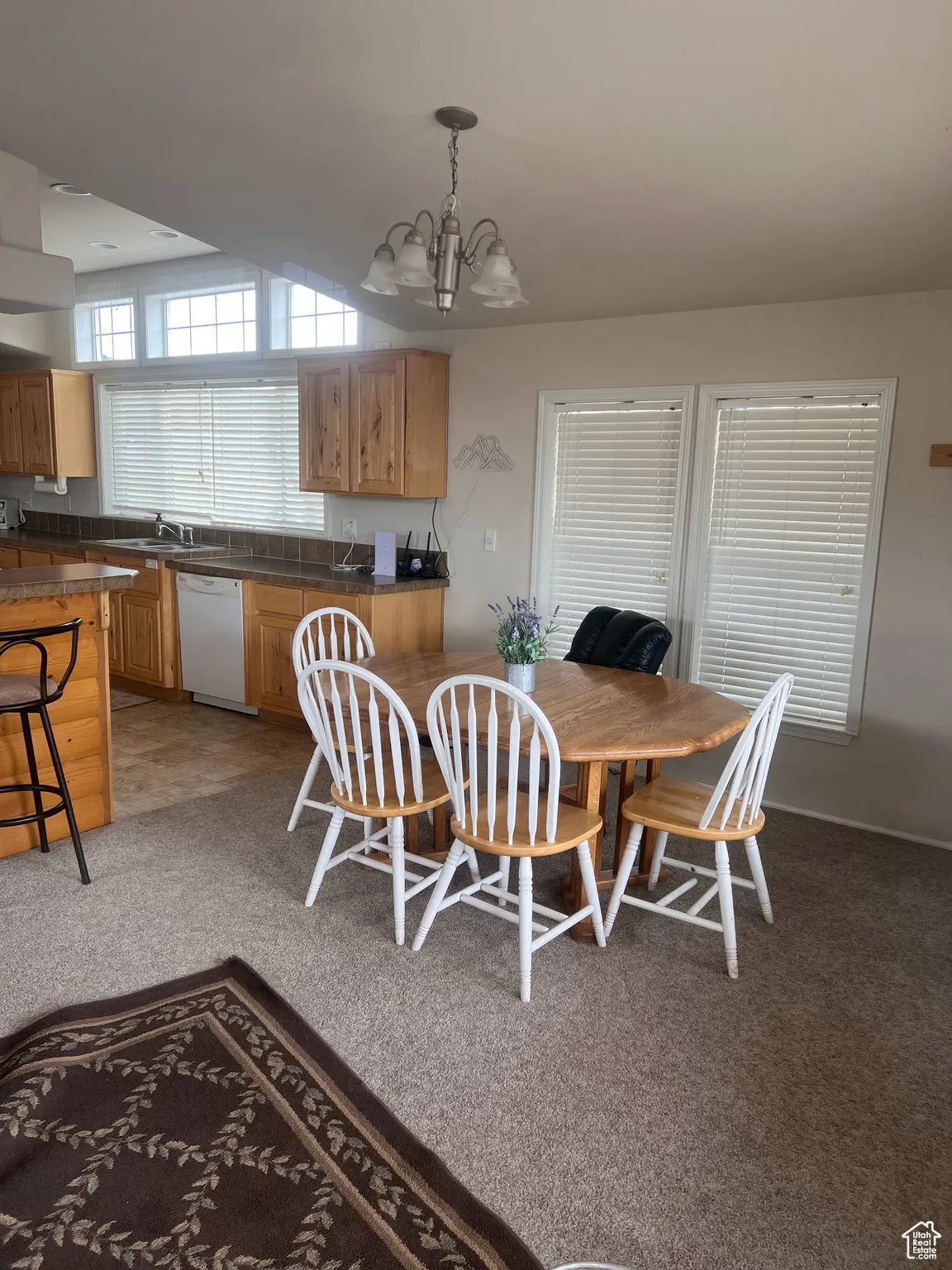 Dining area with light carpet and a chandelier