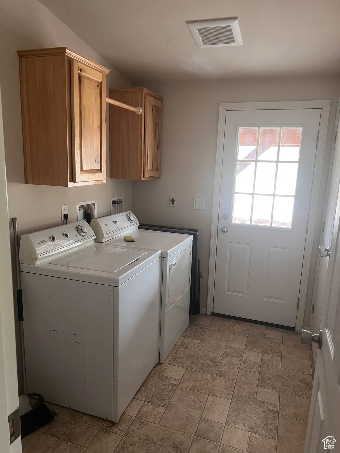 Washroom with cabinet space and washing machine and dryer