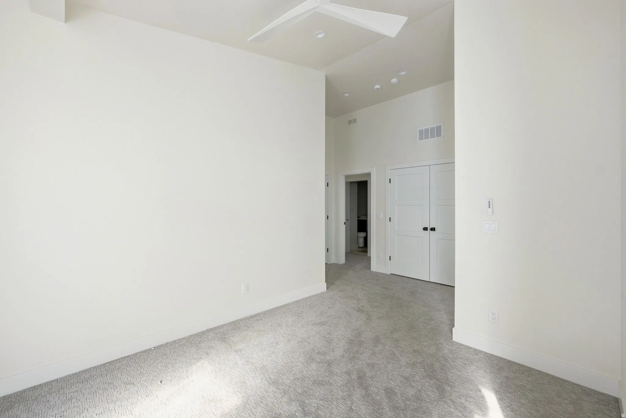 Empty room with a high ceiling and carpet floors