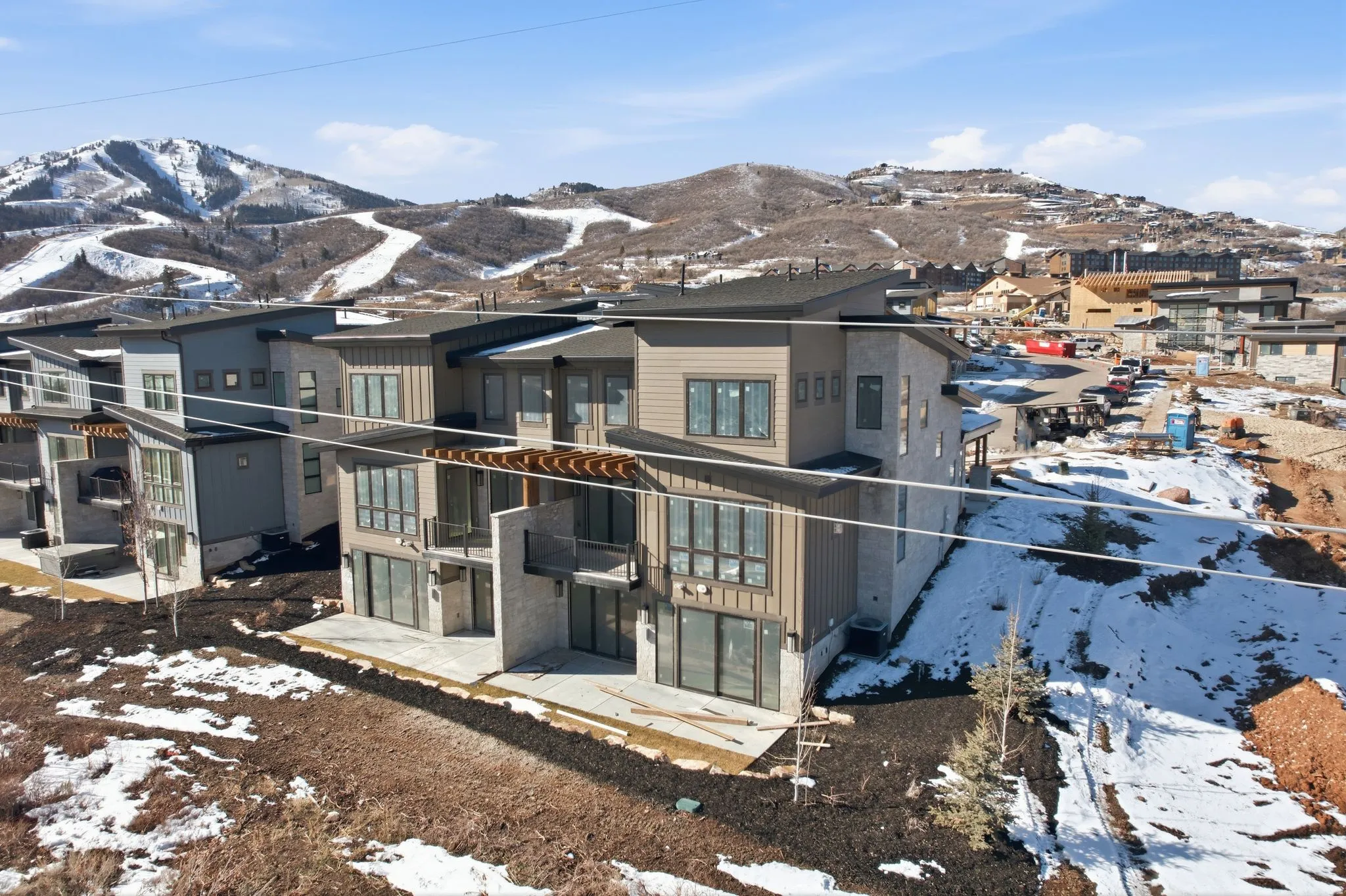 Snow covered property with a mountain view, a residential view, and a balcony