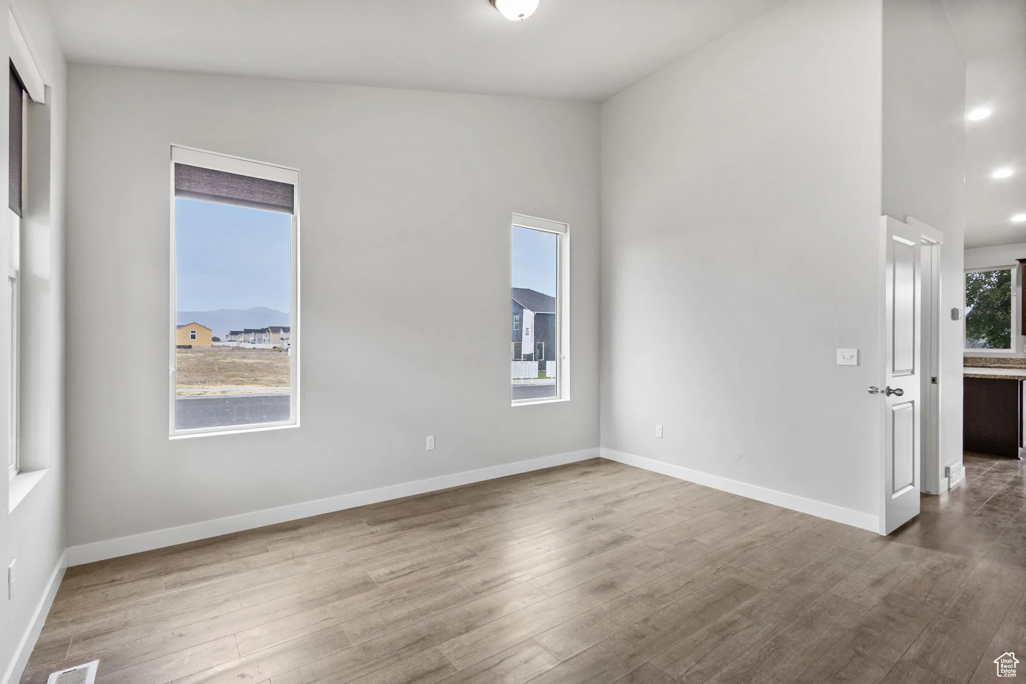 Foyer with vaulted ceiling, healthy amount of natural light, and wood finished floors