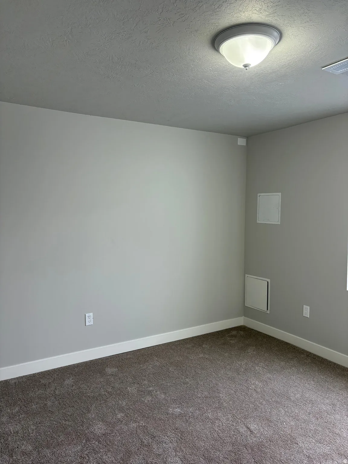 Carpeted bedroom featuring a textured ceiling and baseboards