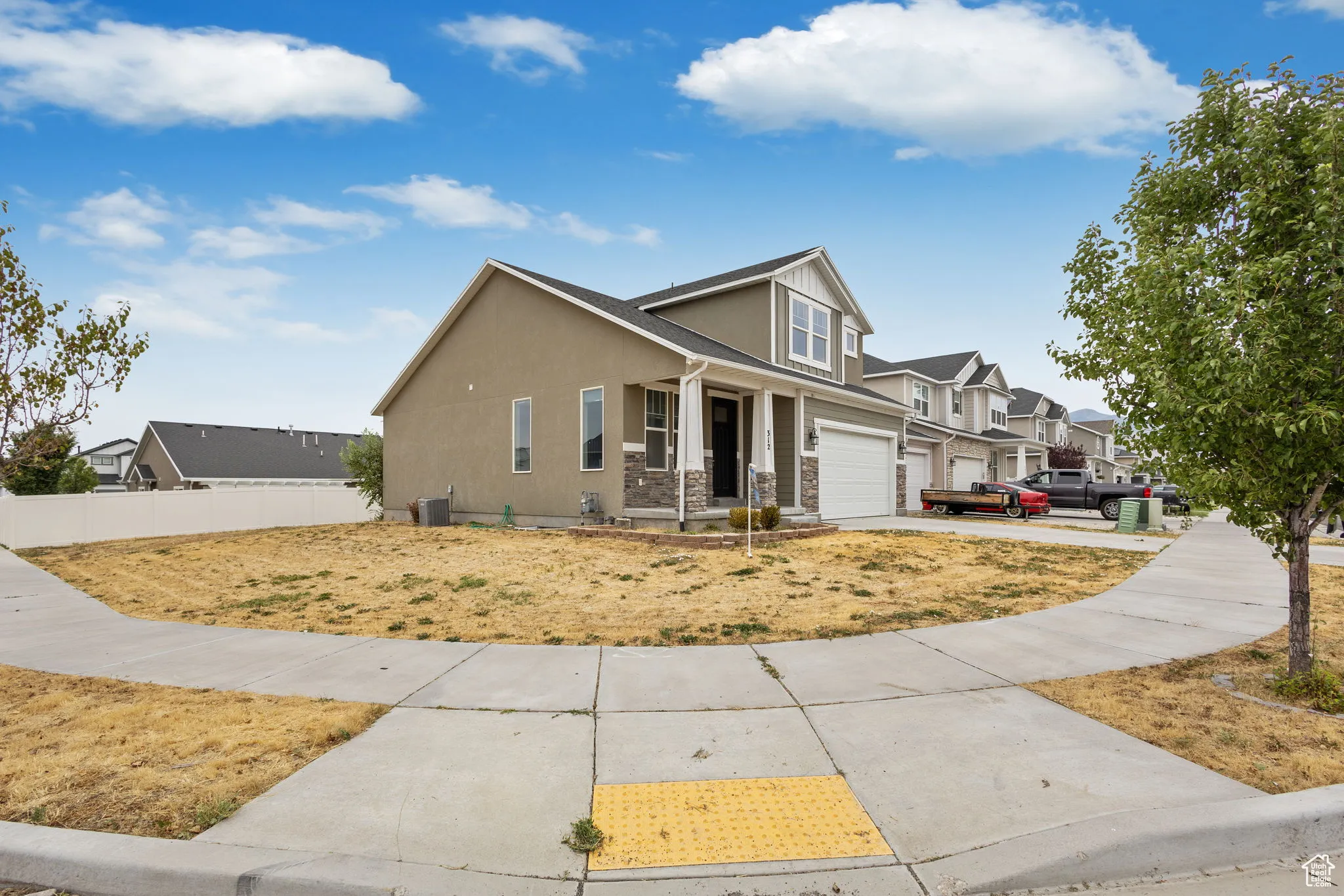 View of front of home featuring stucco siding, driveway, an attached garage, a residential view, and stone siding