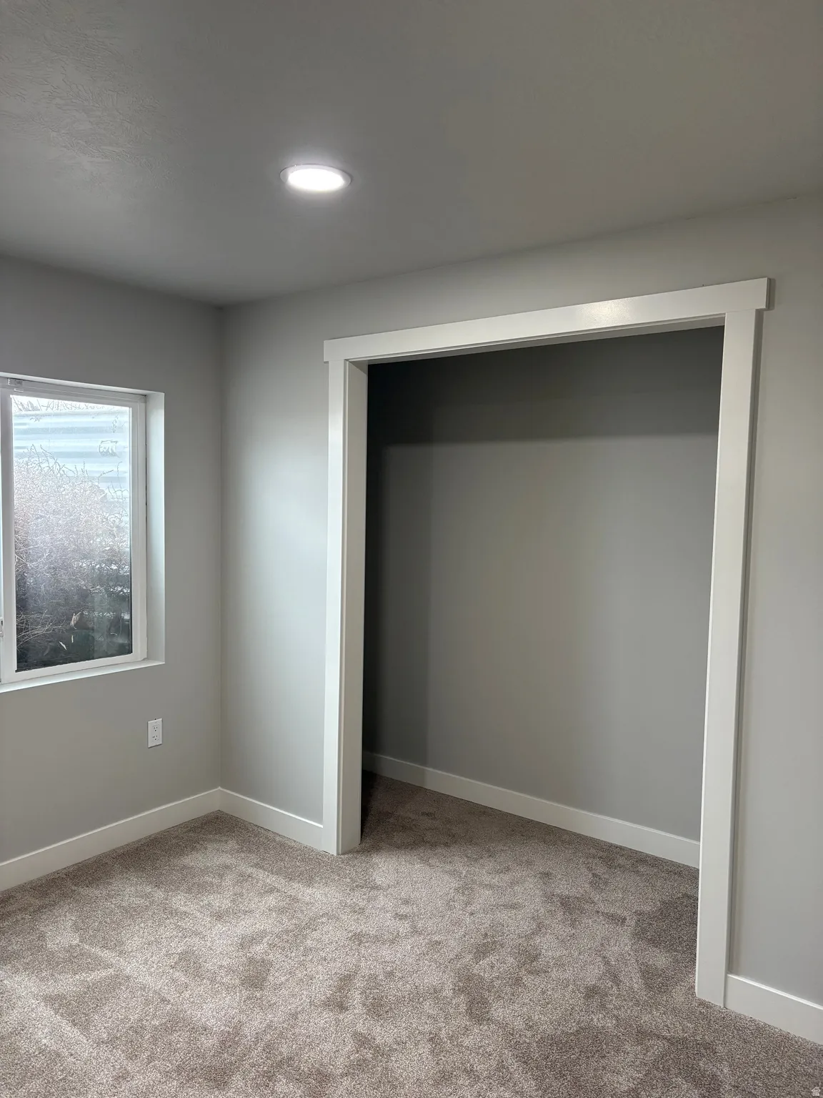 bedroom featuring light colored carpet and baseboards