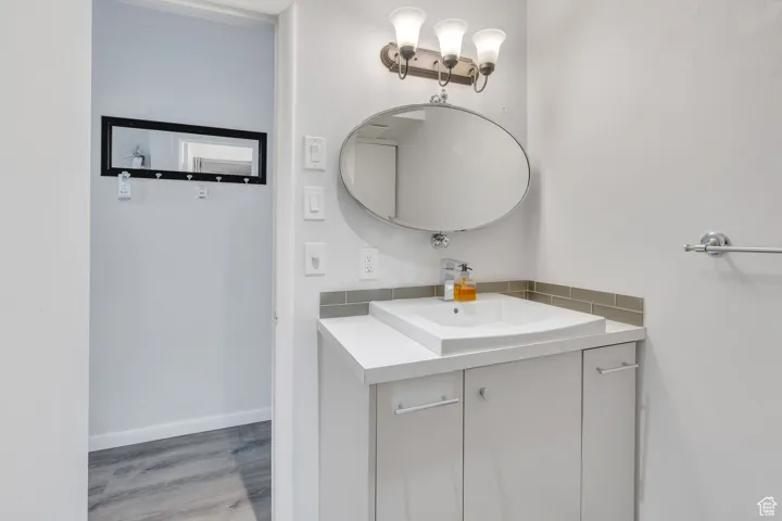 Bathroom featuring baseboards, wood finished floors, and vanity