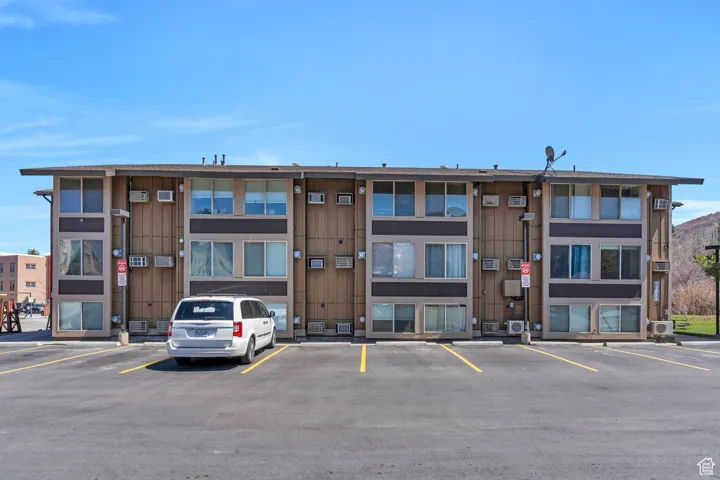 View of building exterior featuring uncovered parking