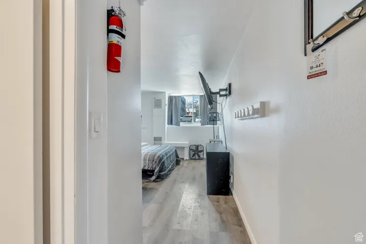 Corridor with baseboards and wood finished floors