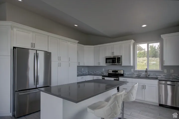 Kitchen with recessed lighting, a sink, white cabinetry, and stainless steel appliances