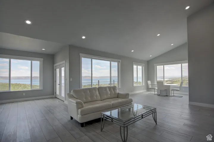 Living room featuring lofted ceiling, wood finished floors, recessed lighting, and baseboards