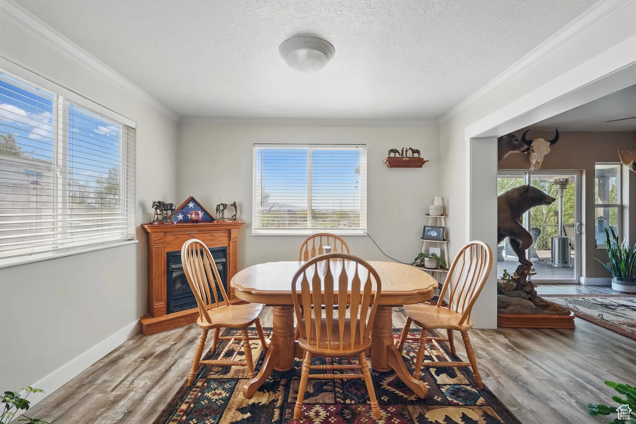 Dining space featuring crown molding, wood finished floors, and a healthy amount of sunlight