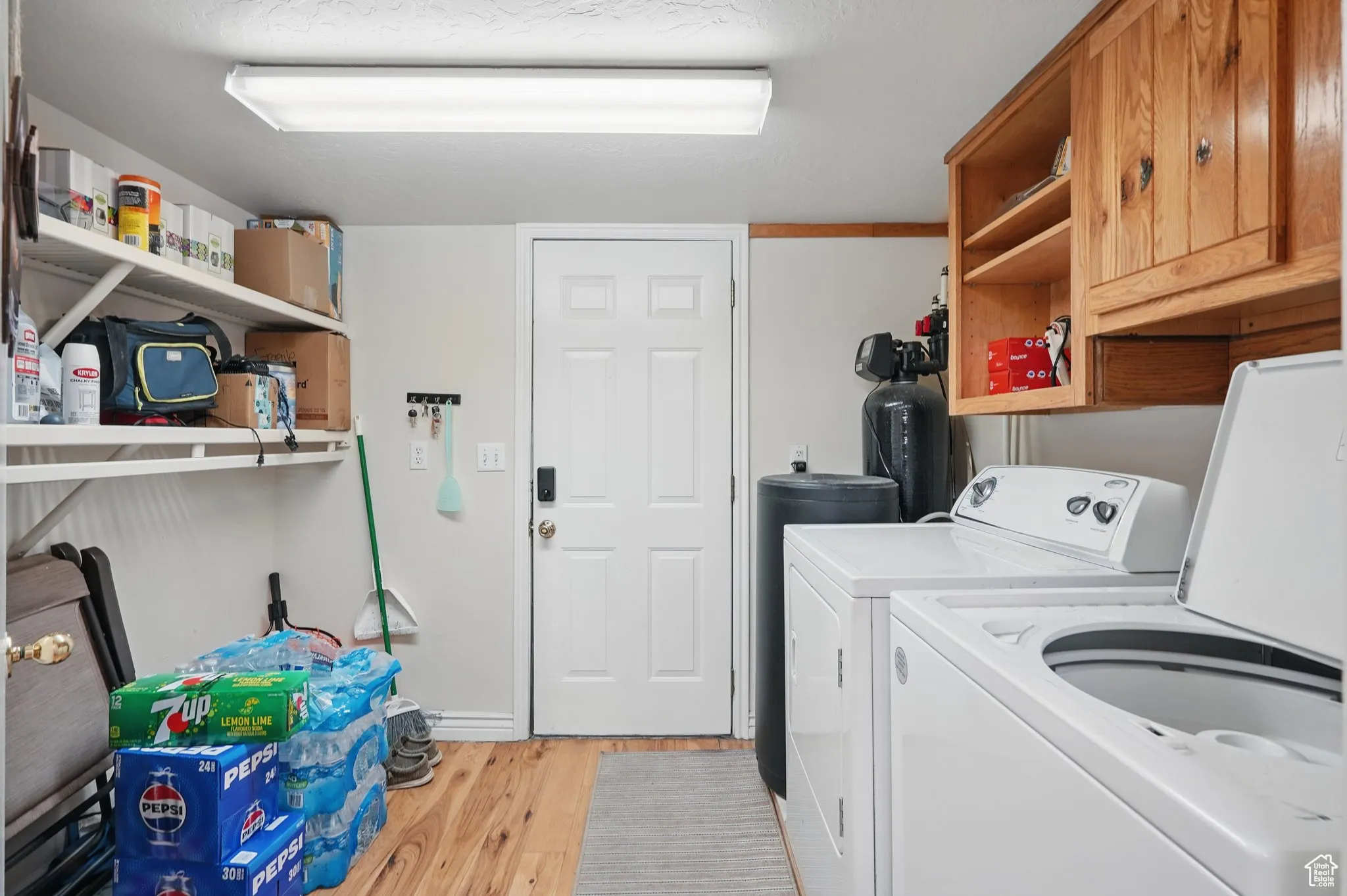 Laundry area featuring cabinet space, light wood finished floors, and independent washer and dryer