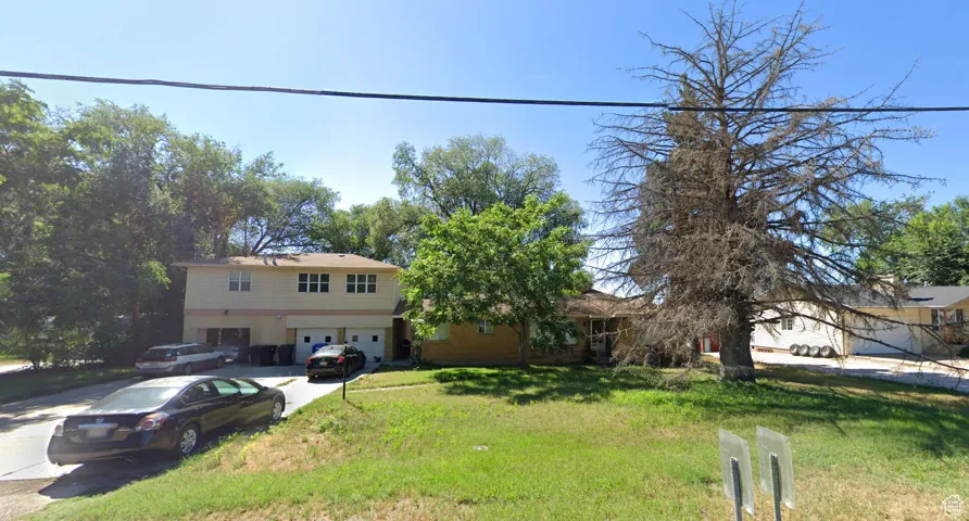 View of front facade with an attached garage, driveway, and a front lawn