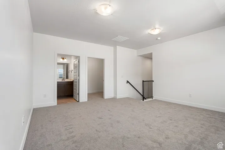 Unfurnished room with light carpet and baseboards