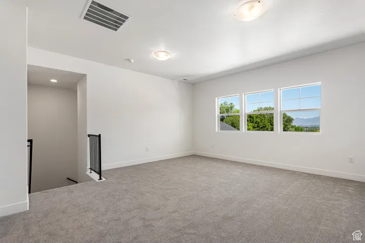 Carpeted empty room featuring baseboards