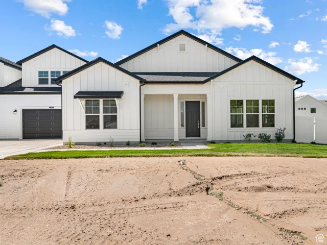 Modern inspired farmhouse with board and batten siding, concrete driveway, and a garage