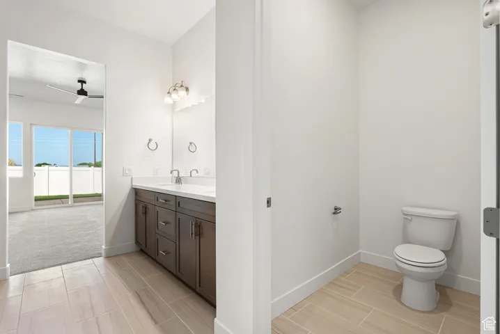 Bathroom featuring vanity, a ceiling fan, and wood finish floors