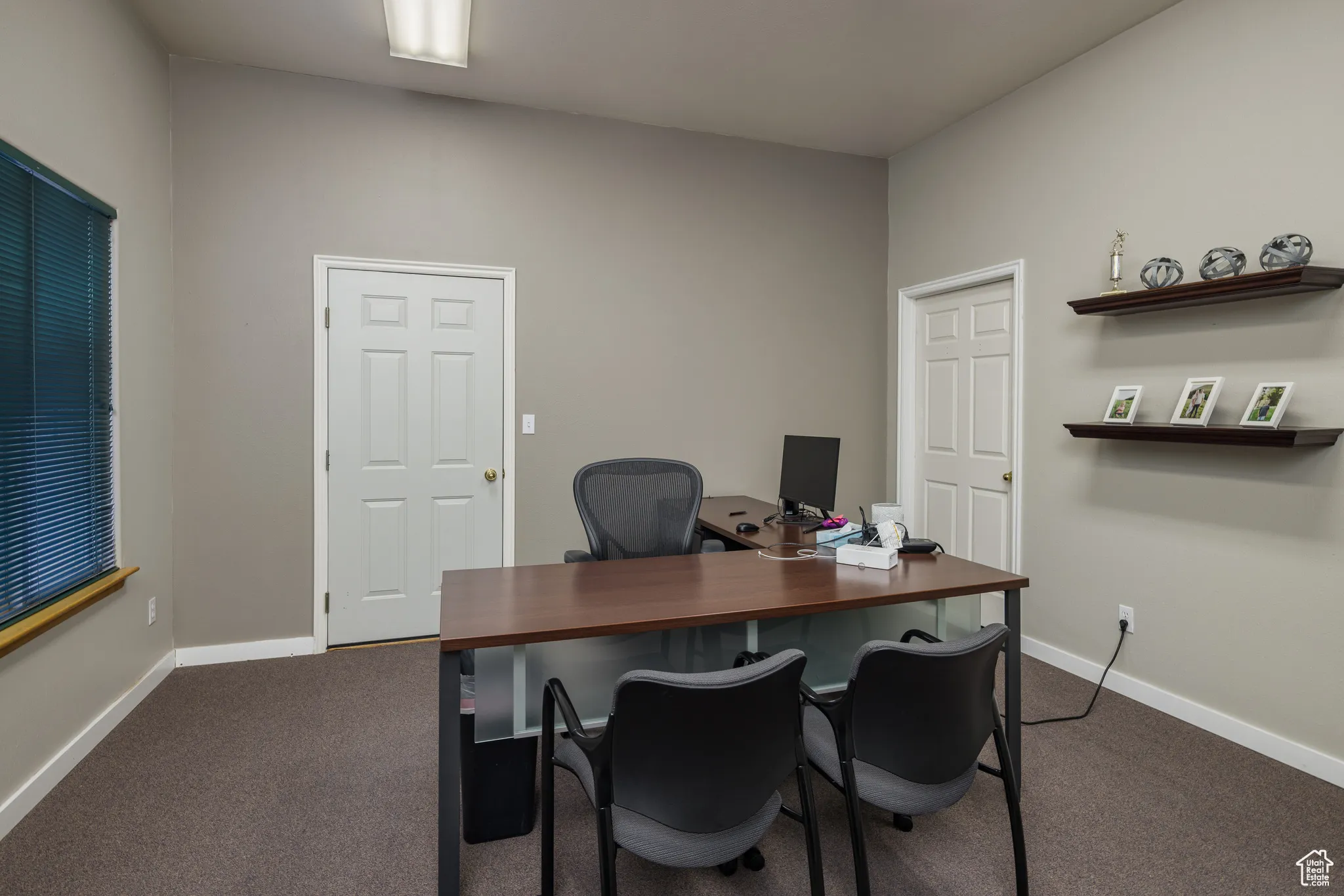 Office space with dark carpet and baseboards