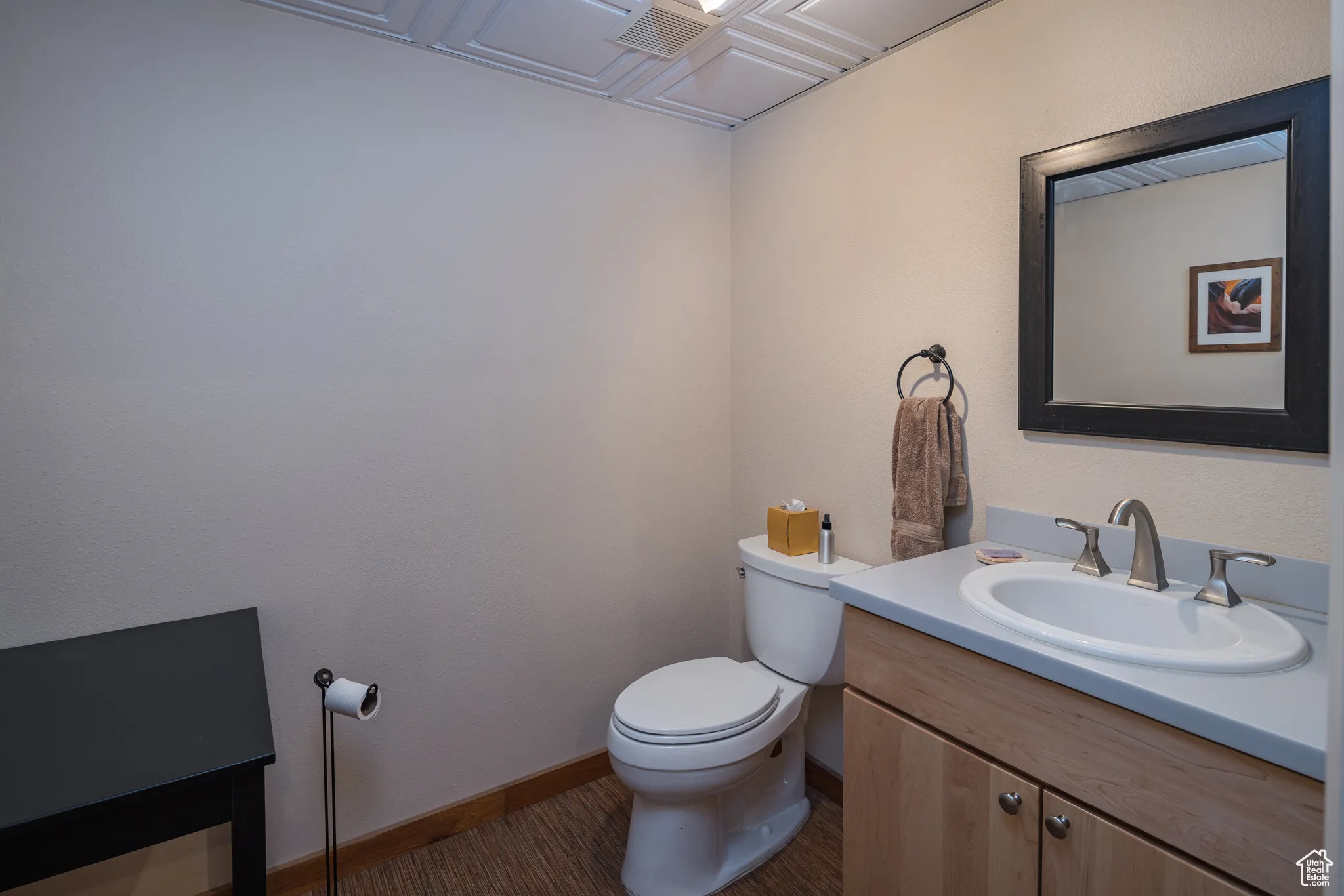 Bathroom featuring baseboards, wood finished floors, toilet, and vanity
