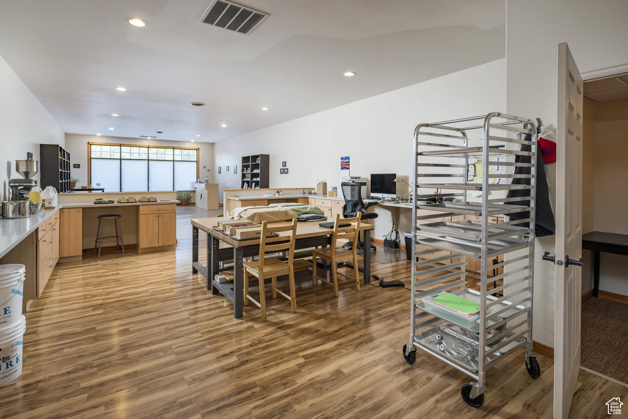 Dining area with light wood finished floors, visible vents, and recessed lighting