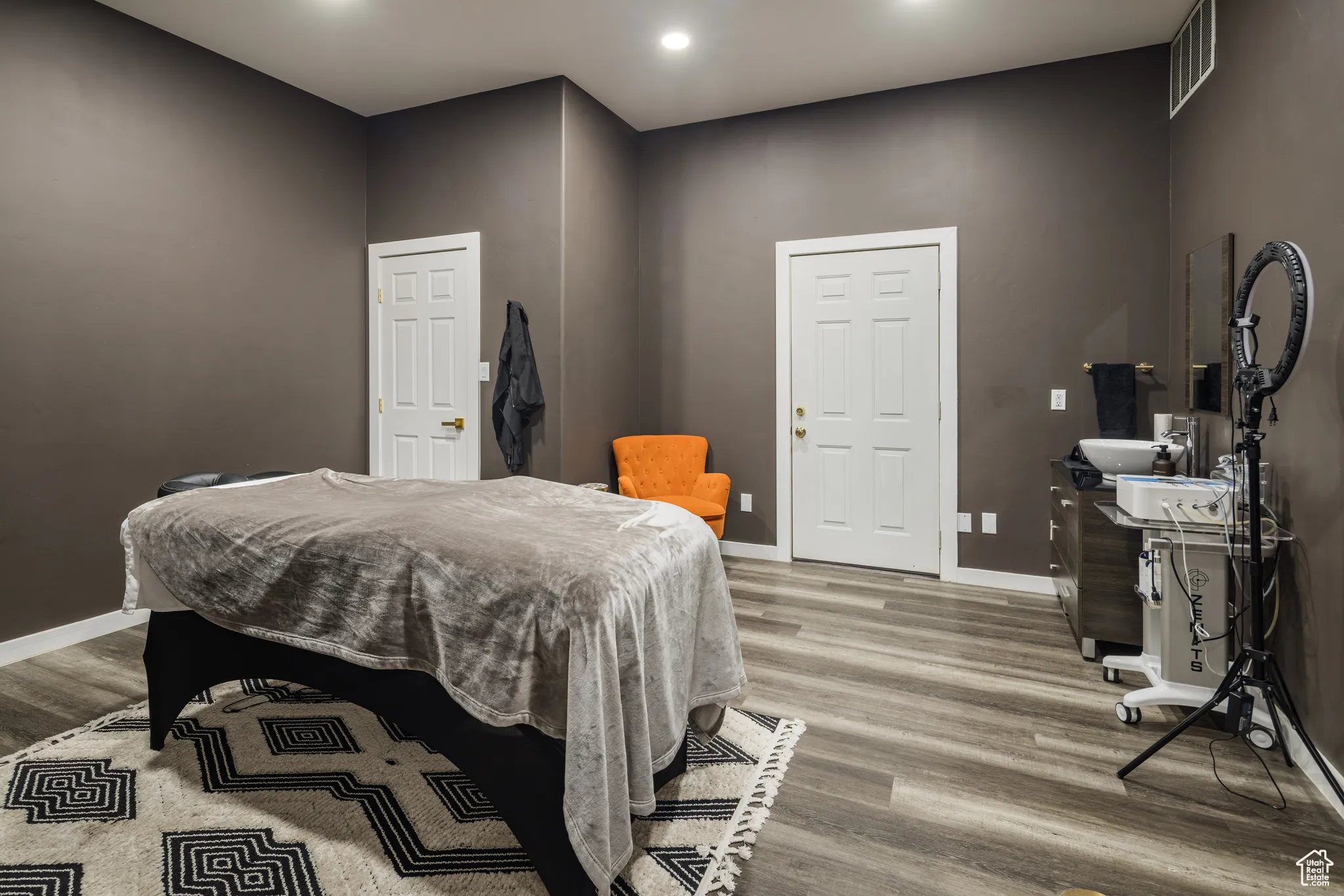 Bedroom with wood finished floors, visible vents, and baseboards