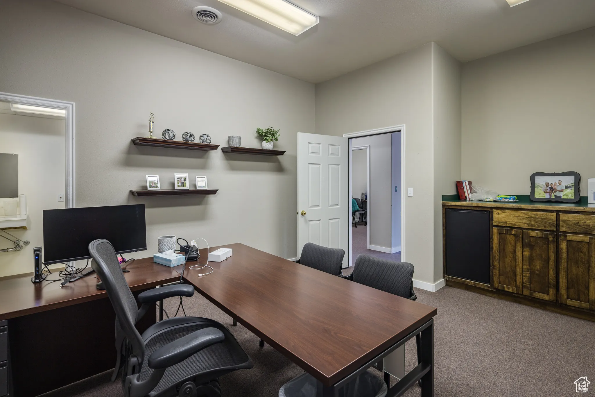Office space featuring baseboards, visible vents, and carpet floors