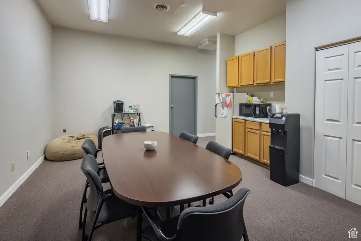 Dining room featuring carpet floors, visible vents, and baseboards