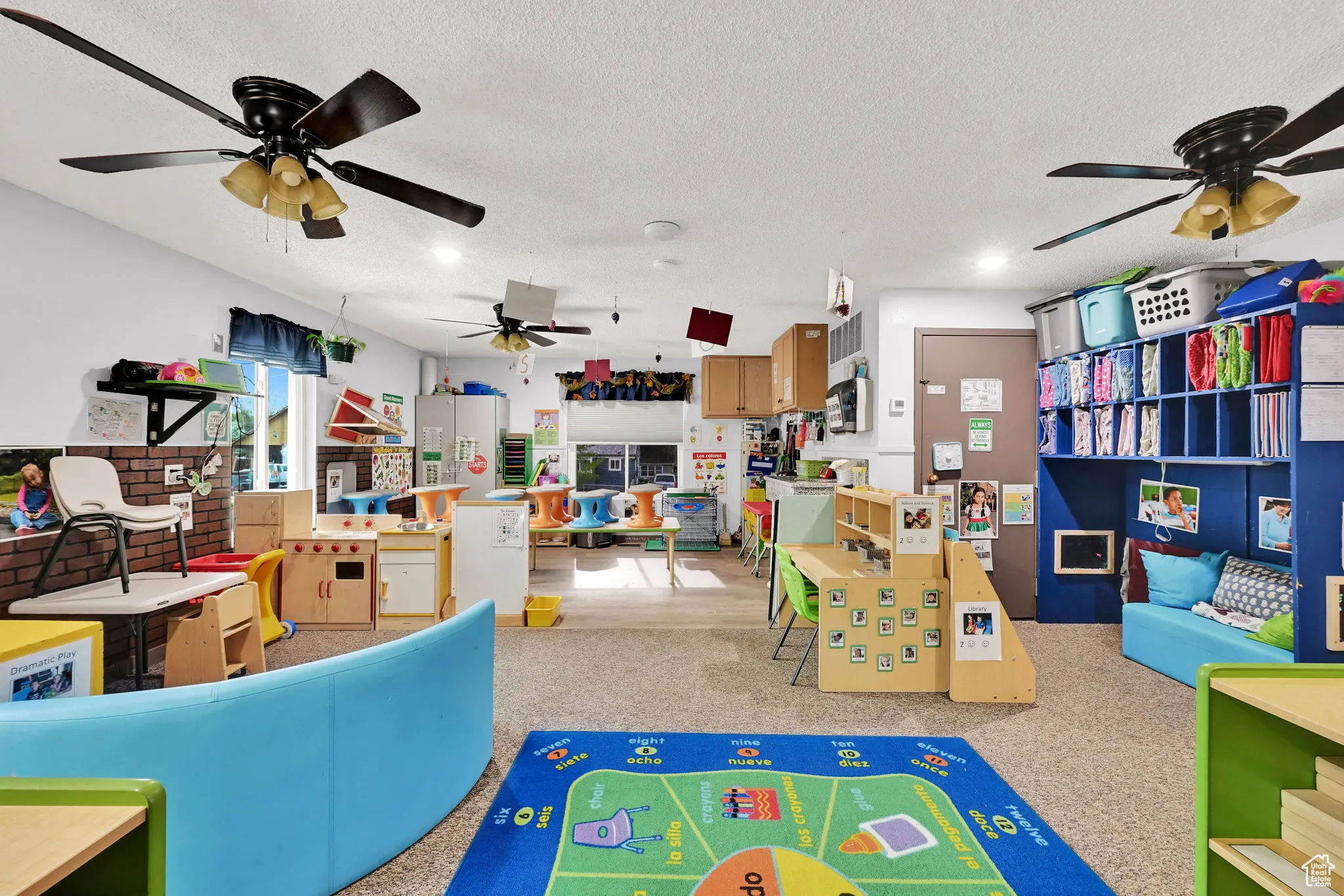 Recreation room with recessed lighting, a ceiling fan, and a textured ceiling