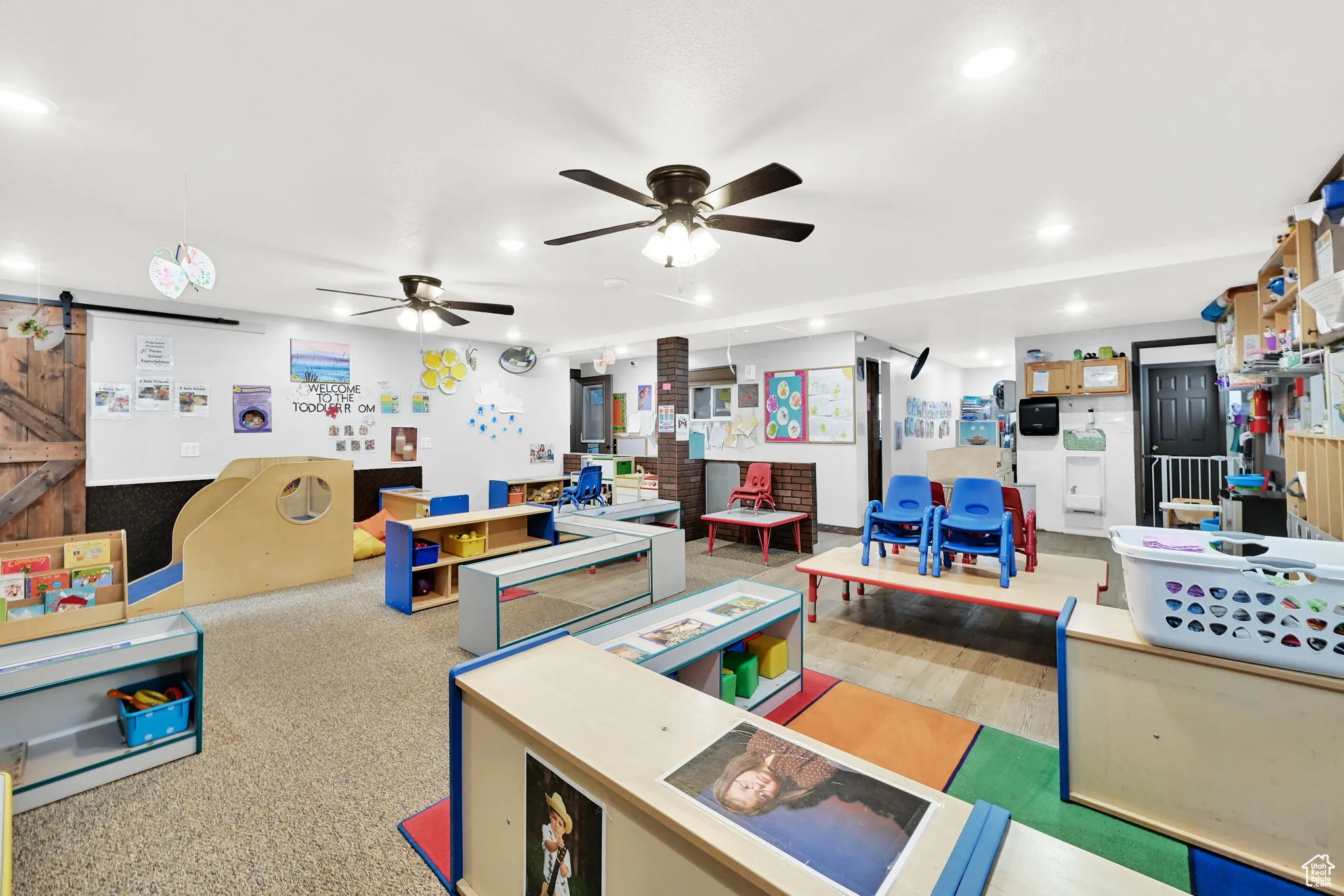 Recreation room featuring a barn door, ceiling fan, and recessed lighting