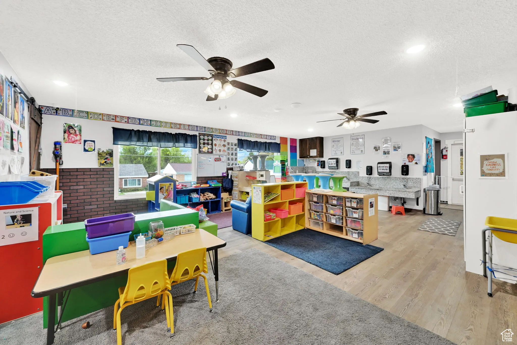 Recreation room with recessed lighting, a textured ceiling, a ceiling fan, and wood finished floors