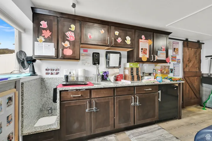 Bar featuring refrigerator, light wood-style flooring, and a barn door