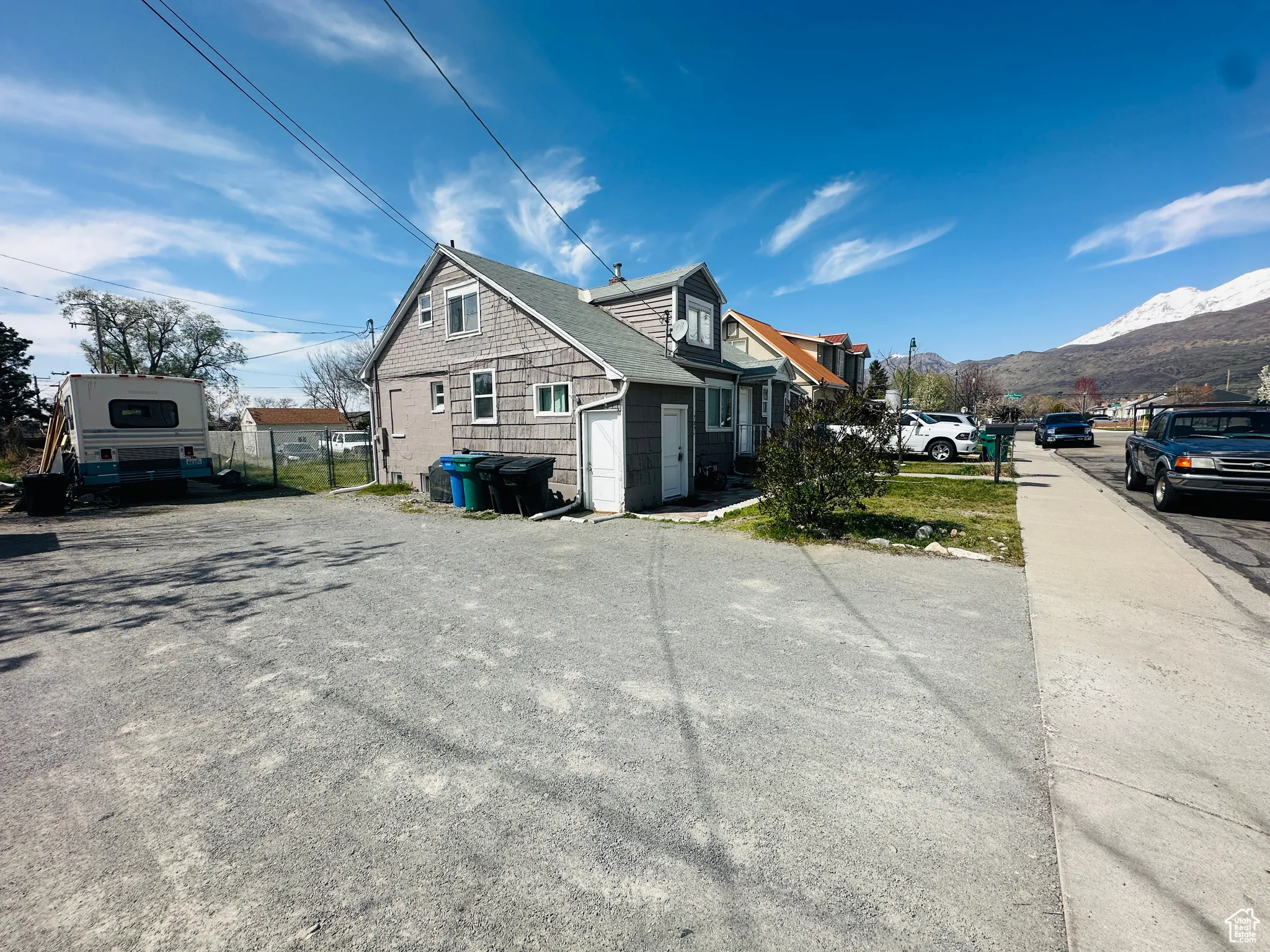 View of side of home with a mountain view and fence