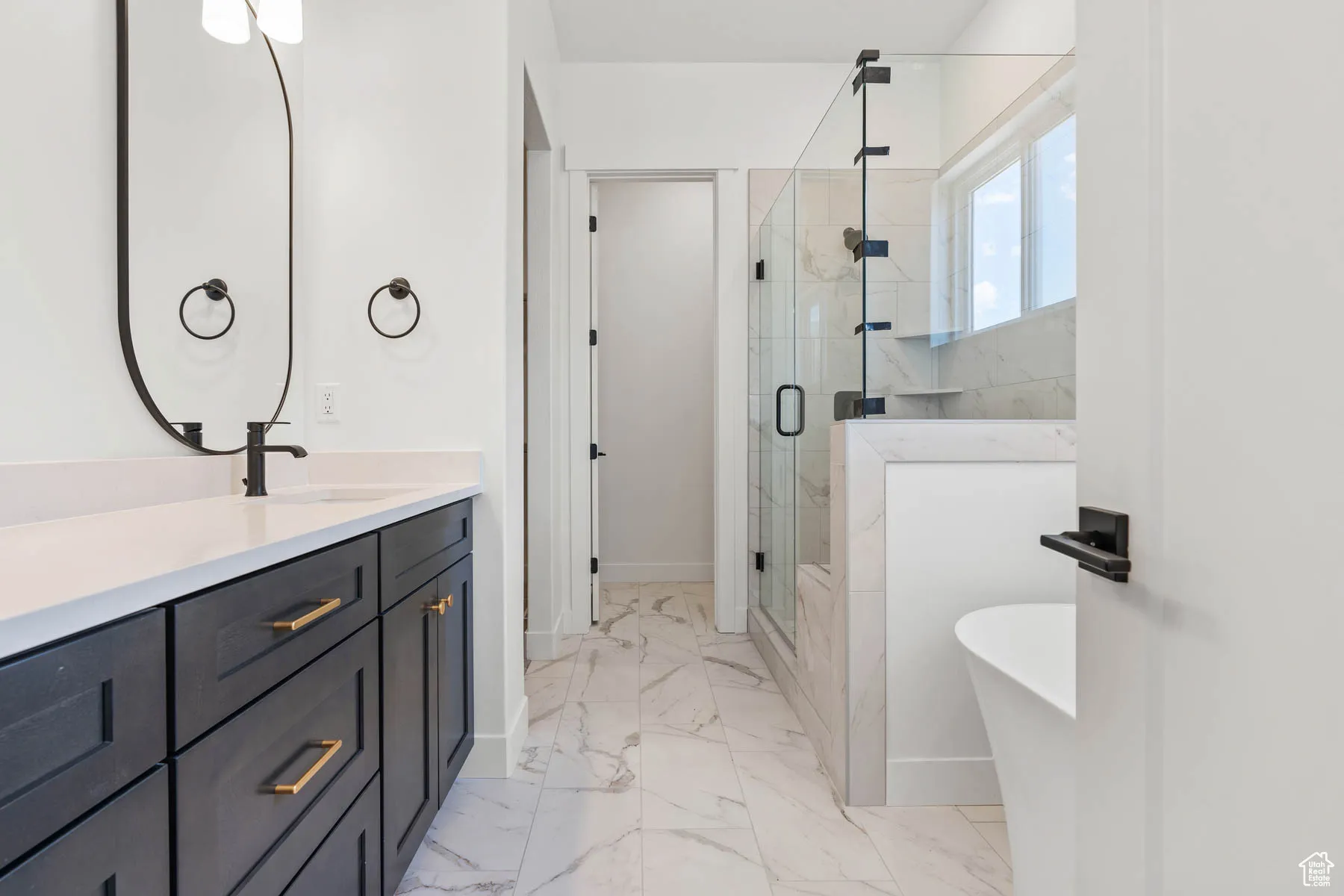 Full bath with a freestanding tub, baseboards, a stall shower, and marble finish floor