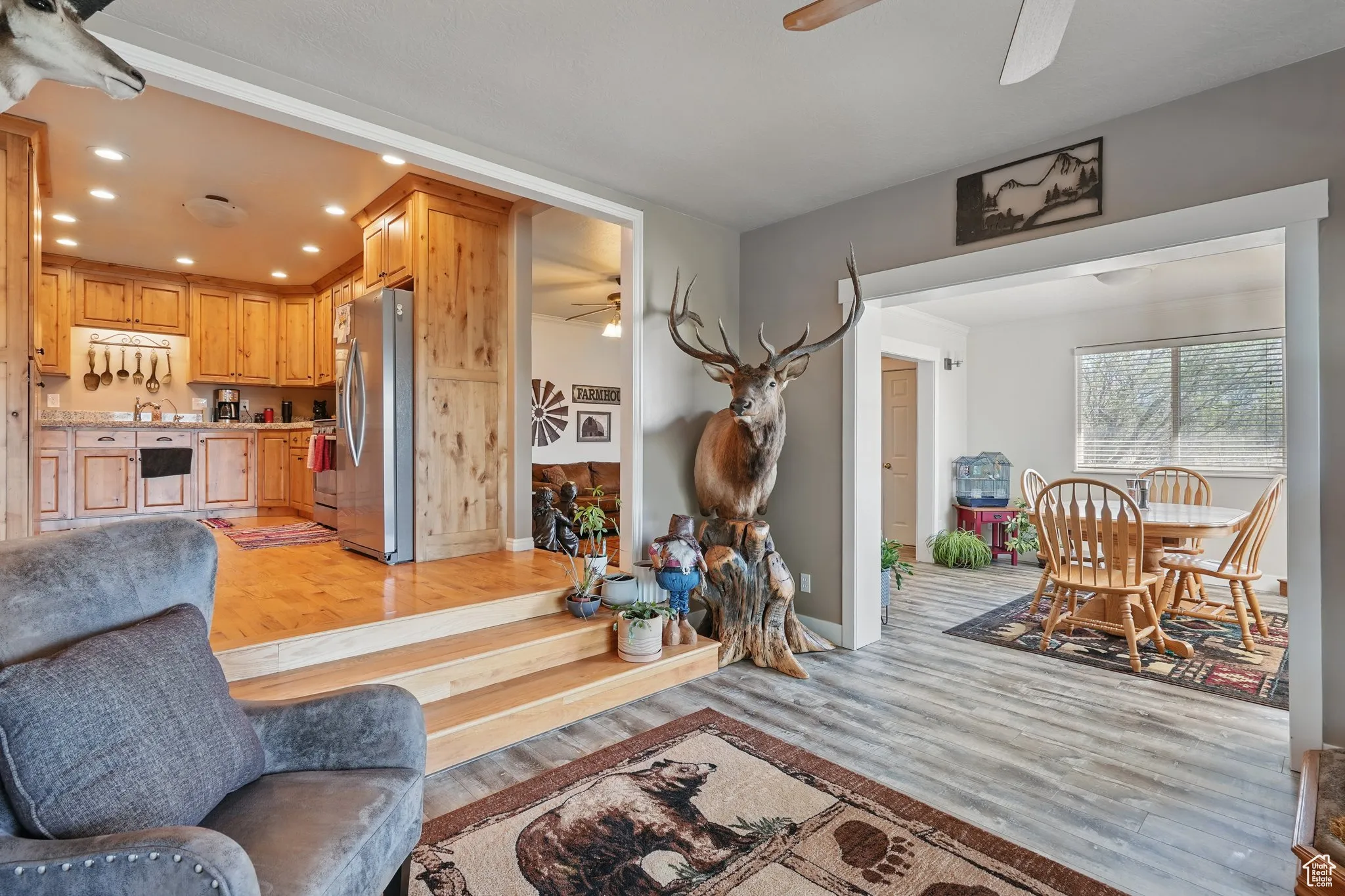 Living room with a ceiling fan, baseboards, recessed lighting, and light wood-style flooring