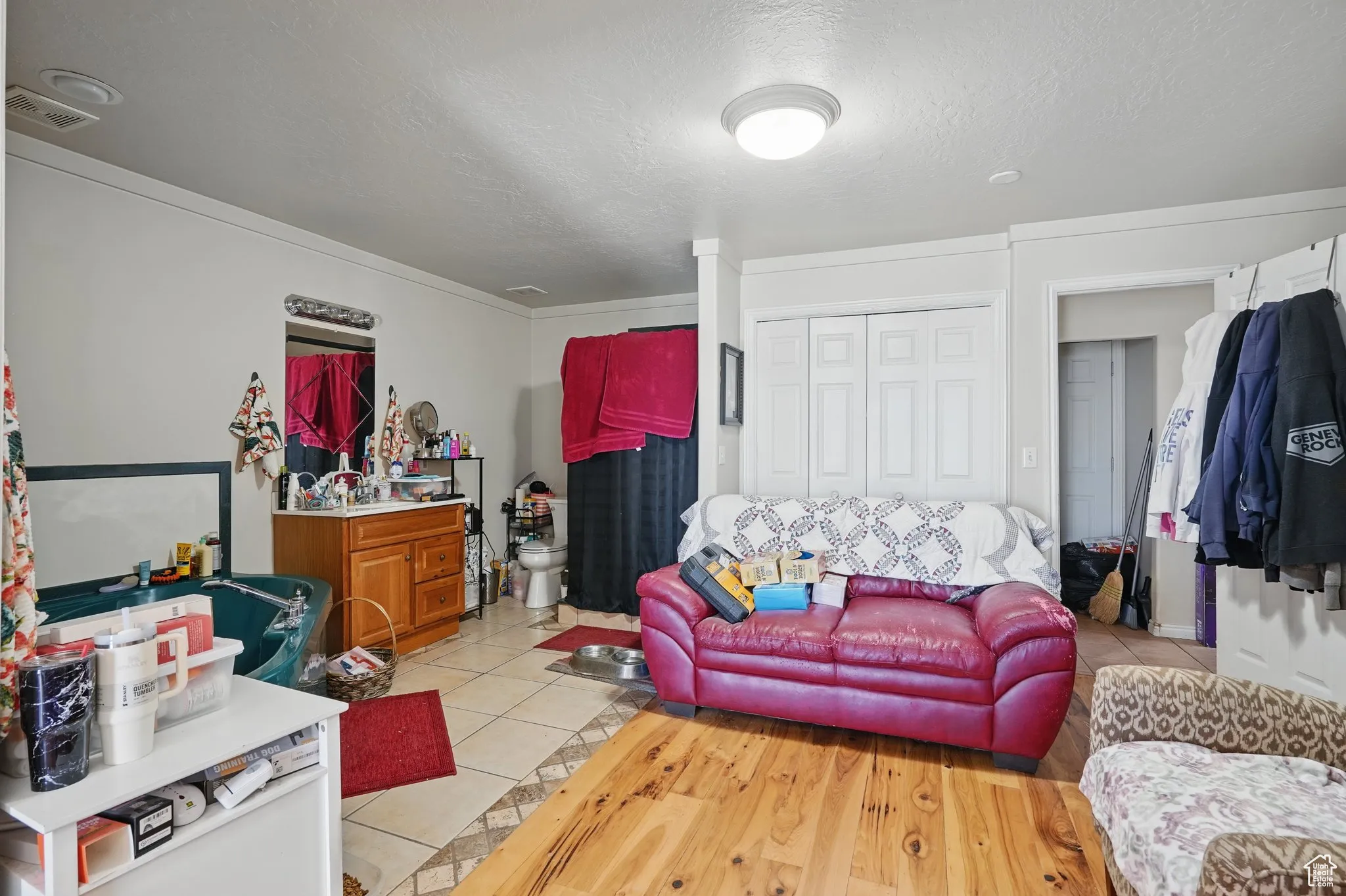 Living area with visible vents, a textured ceiling, and light tile patterned floors