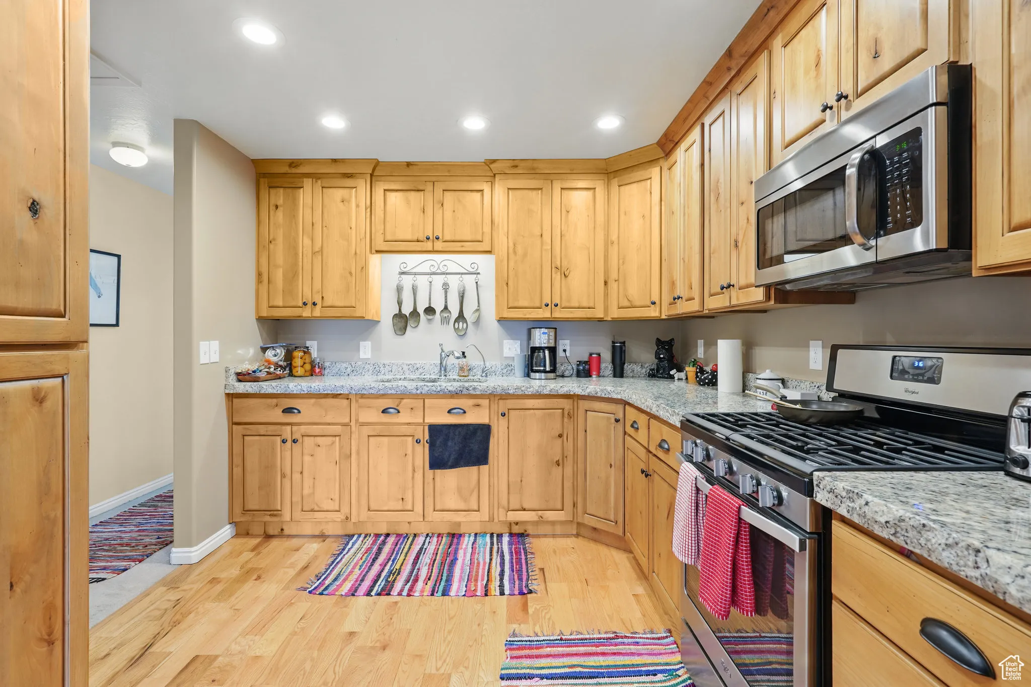 Kitchen with appliances with stainless steel finishes, baseboards, recessed lighting, and light wood-style flooring
