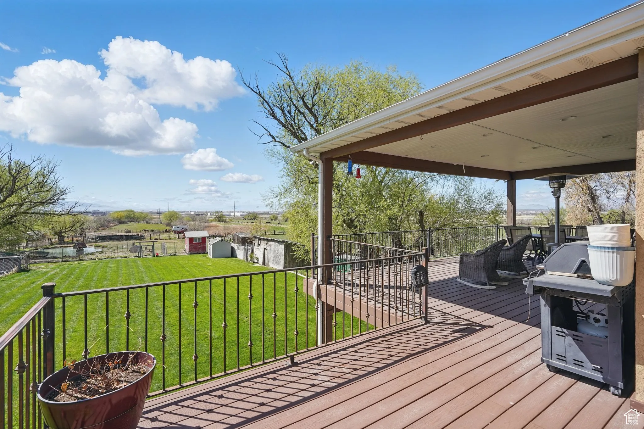 Wooden terrace featuring a lawn, an outbuilding, and a water view
