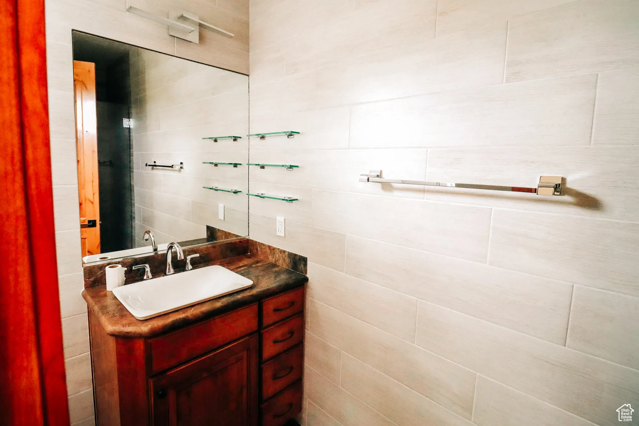Bathroom featuring vanity and tile walls