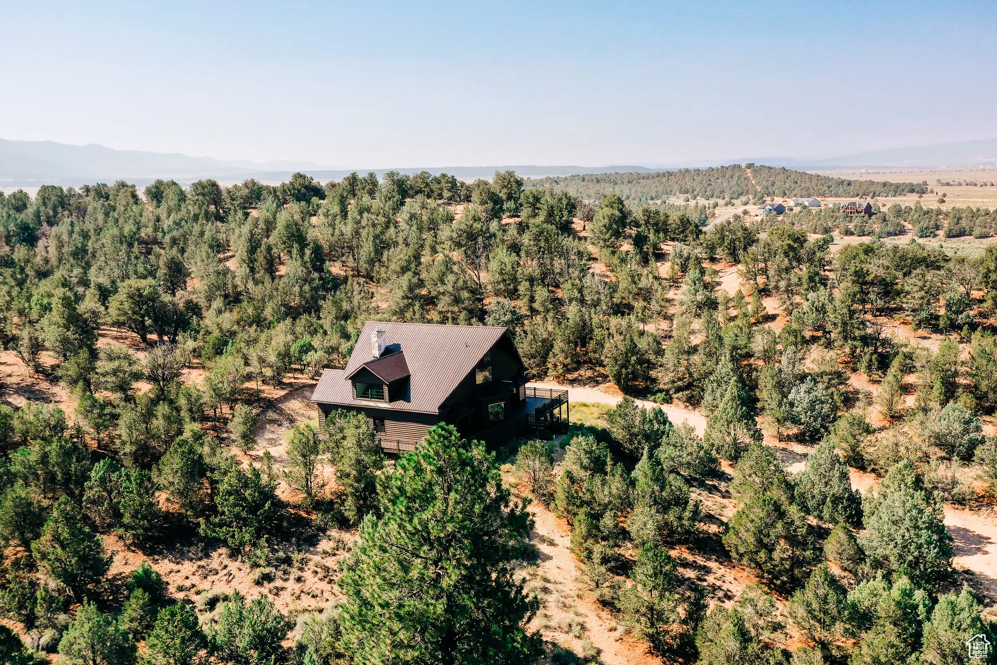 View from above of property featuring mountains and a heavily wooded area