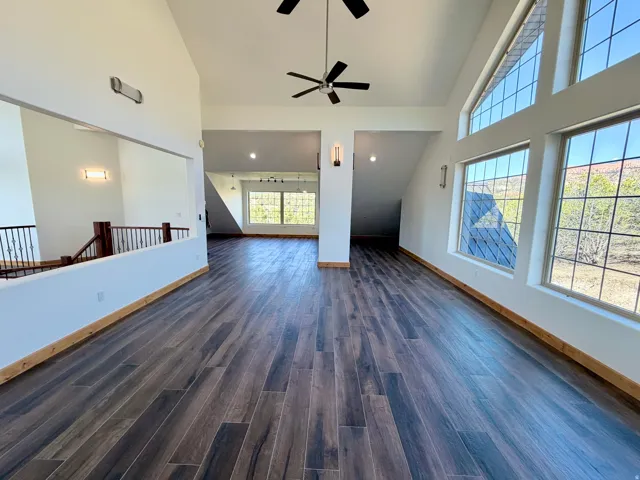Spacious interior featuring high ceilings, wood-finish flooring, and expansive windows